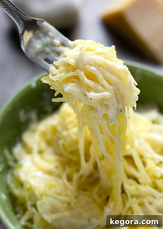 Squash Noodle Express 4 Close-up photograph of a fork scooping up golden strands of spaghetti squash from a vibrant green bowl, highlighting its pasta-like texture.