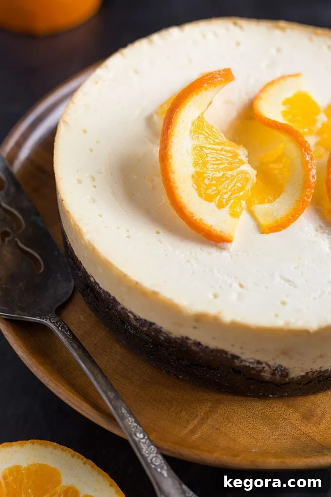 Velvet Orange Pressure Cooker Cheesecake 3 Whole Pressure Cooker Dreamy Orange-Cheesecake on a wooden platter topped with orange