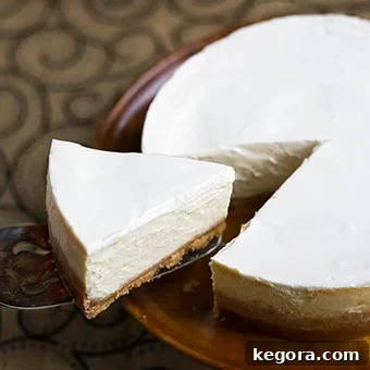 Velvet Orange Pressure Cooker Cheesecake 6 Slice of Instant Pot New York Cheesecake on serving spoon cut out of whole cheesecake