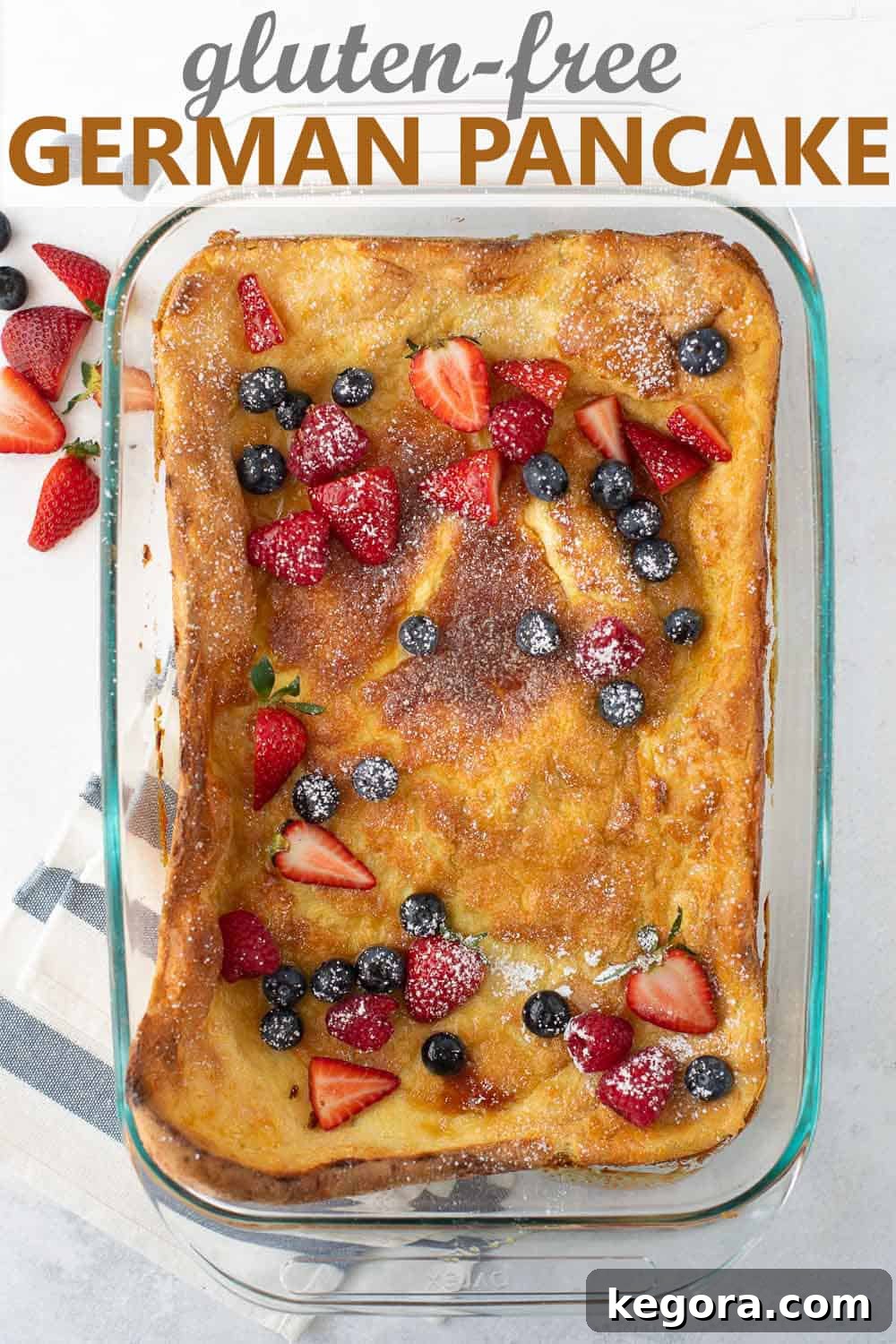 An overhead shot of a freshly baked, gluten-free Dutch baby still in the pan, showing its impressive rise and golden-brown crust.
