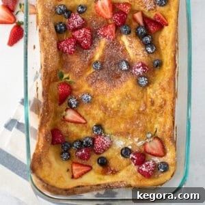 Overhead shot of gluten-free German pancake in a glass pan with fresh berries, ready to be served.