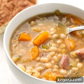 Instant Pot Ham Hock and Bean Soup in a white bowl with spoon