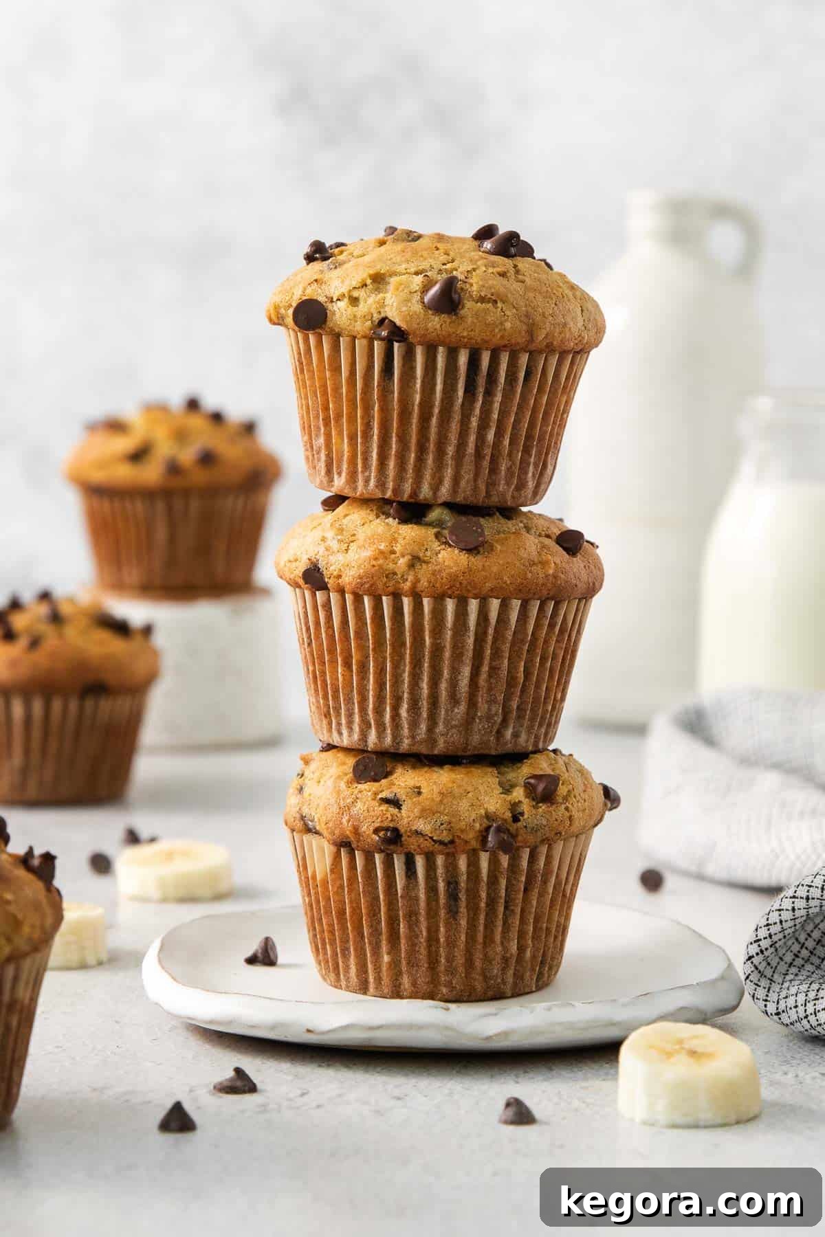 Three golden-brown gluten-free banana muffins stacked on top of each other, showcasing their fluffy texture and delicious appearance.