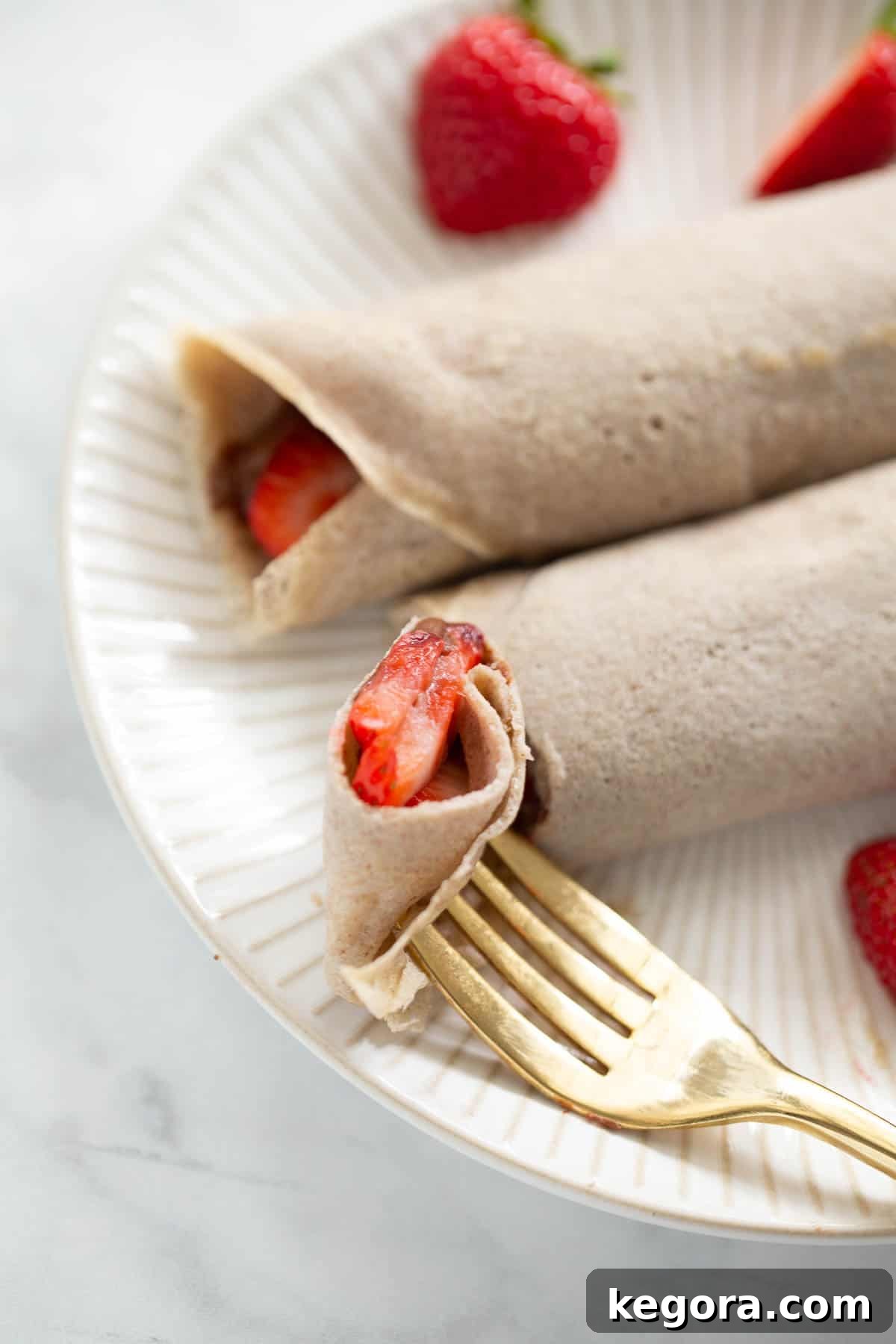 Close-Up of Buckwheat Crepe with Fork close up shot of a buckwheat crepe with a bite taken out by a fork, showing the delicate texture