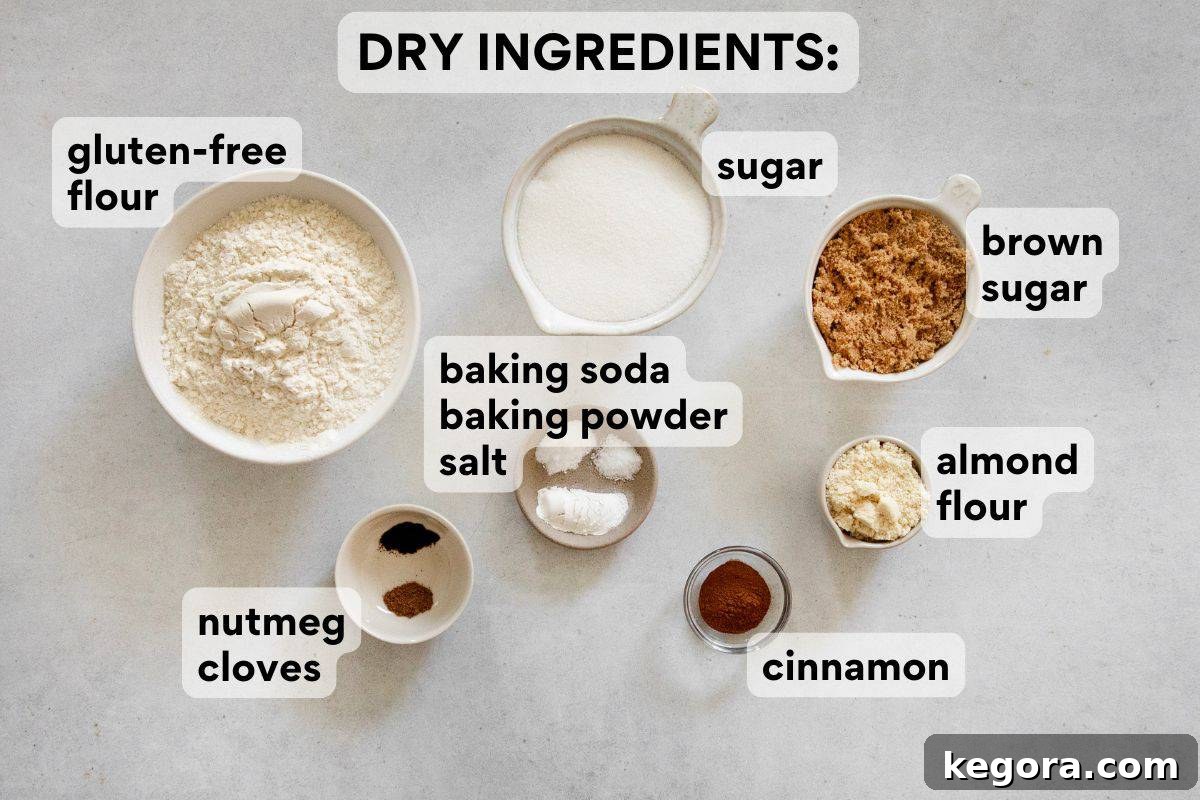 Dry ingredients for pumpkin muffins, including gluten-free flour, almond flour, sugars, and spices, measured and labeled in individual bowls.
