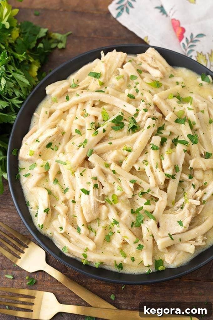 Comforting Instant Pot Chicken Noodles 2 Instant Pot Chicken and Noodles in a black bowl on wooden board next to golden forks