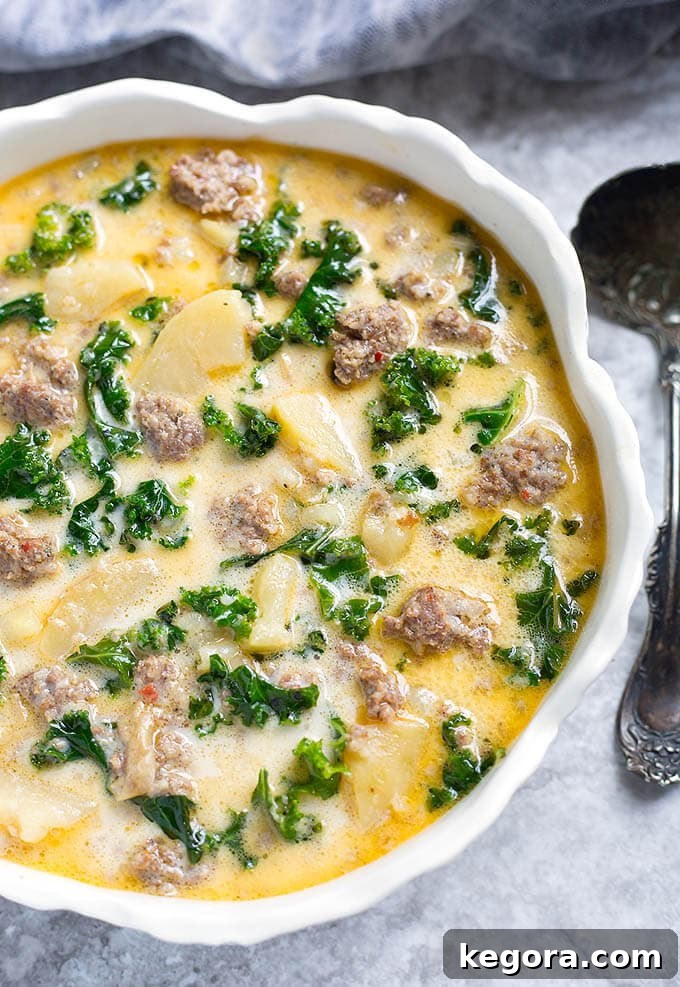 Instant Pot Creamy Tuscan Sausage and Potato Soup 2 Instant Pot Zuppa Toscana (Sausage Potato Soup) in a white bowl with scalloped edges next to spoon