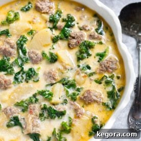 Instant Pot Creamy Tuscan Sausage and Potato Soup 4 Instant Pot Zuppa Toscana (Sausage and Potato Soup) in a white bowl with scalloped edge next to silver spoon