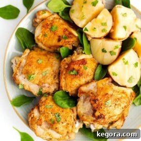 Effortless Instant Pot Chicken and Potato Dinner 6 Instant Pot Chicken Thighs and potatoes on a white plate with brown rim sprinkled with baby spinach