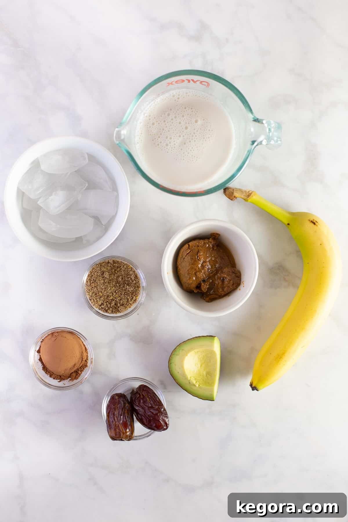 Ingredients for Chocolate Avocado Banana Smoothie Ingredients for a healthy breakfast drink including banana, chocolate, avocado, almond milk, and dates.