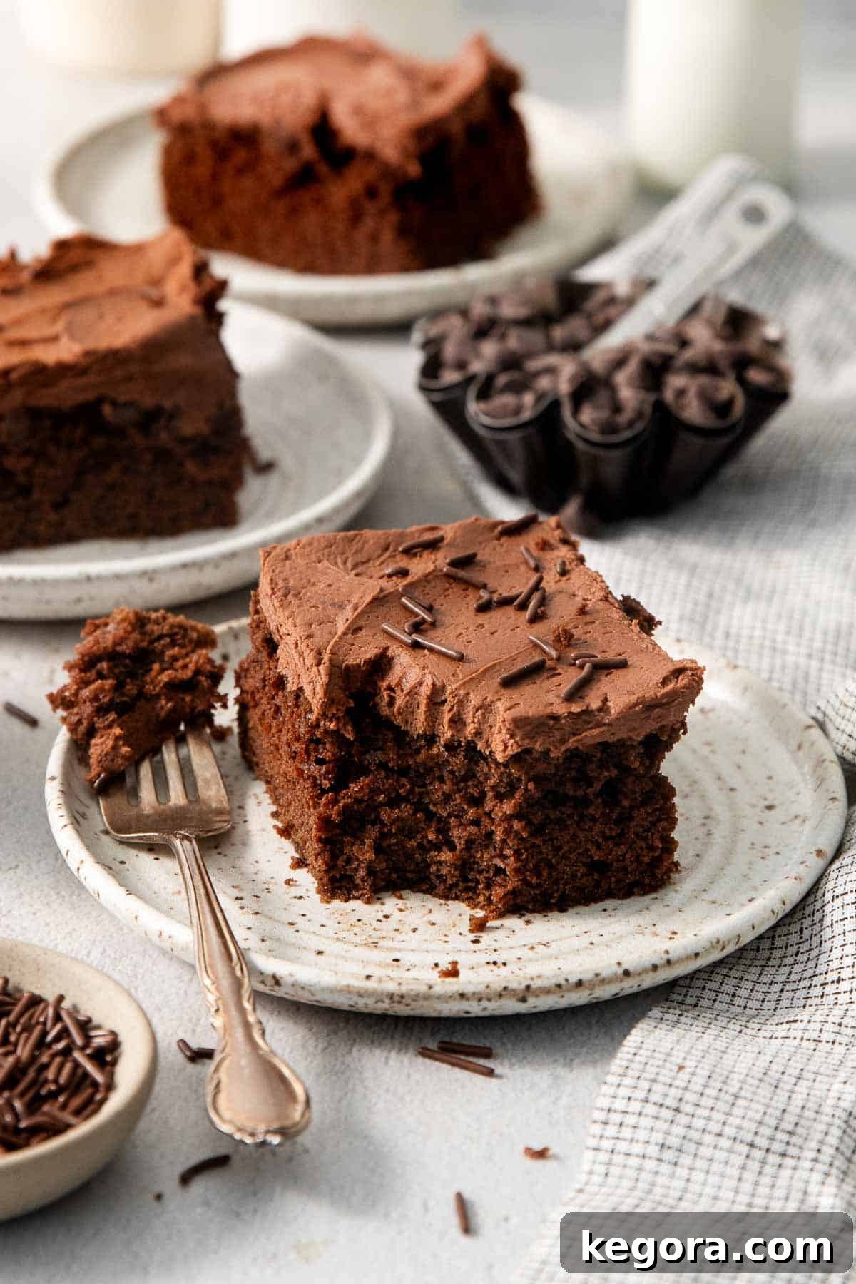 Effortless Gluten-Free Chocolate Masterpiece 3 a piece of chocolate cake on a plate with one bite on a fork.