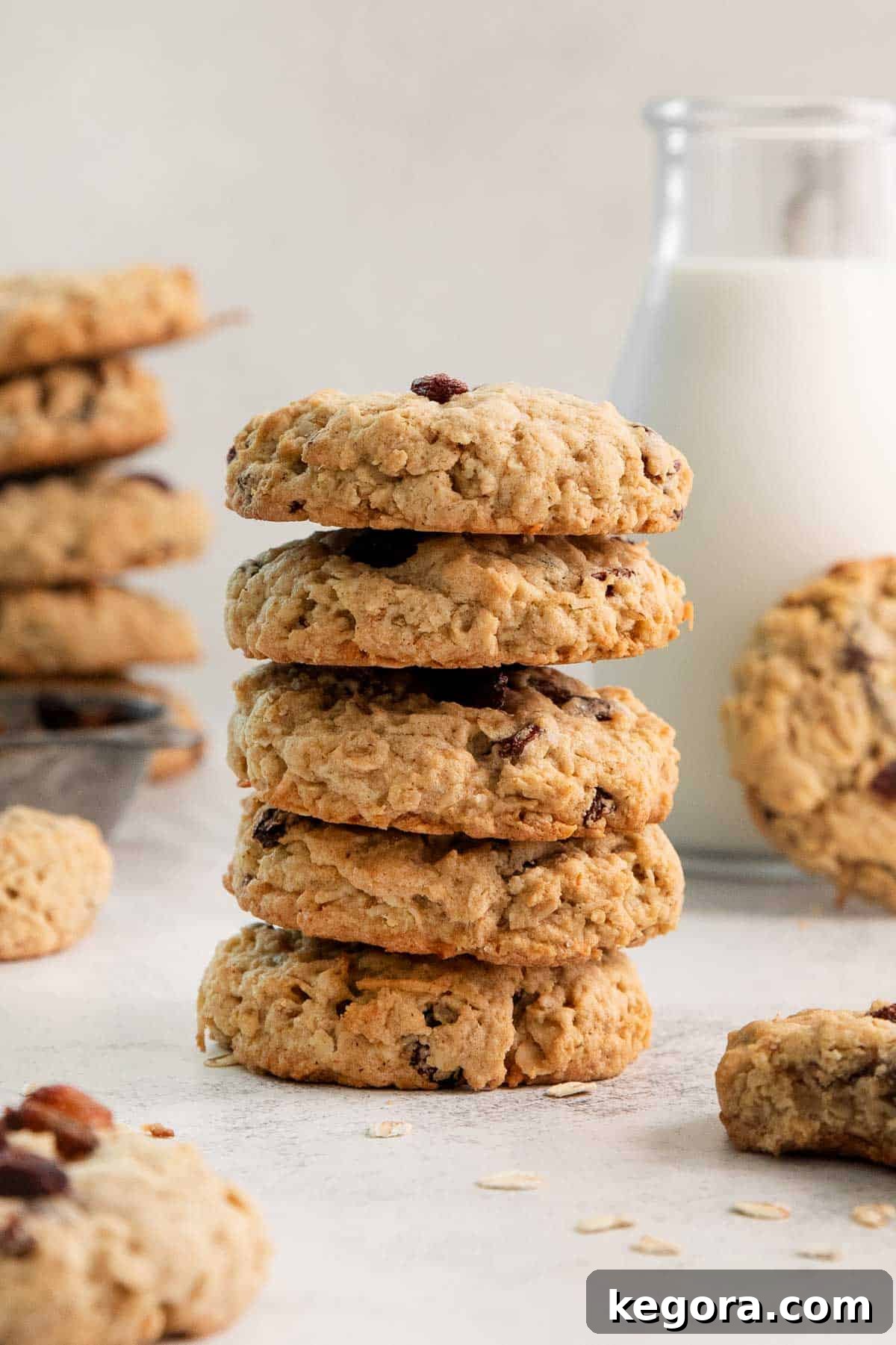 A perfectly arranged stack of five golden-brown gluten-free oatmeal raisin cookies, highlighting their soft texture.