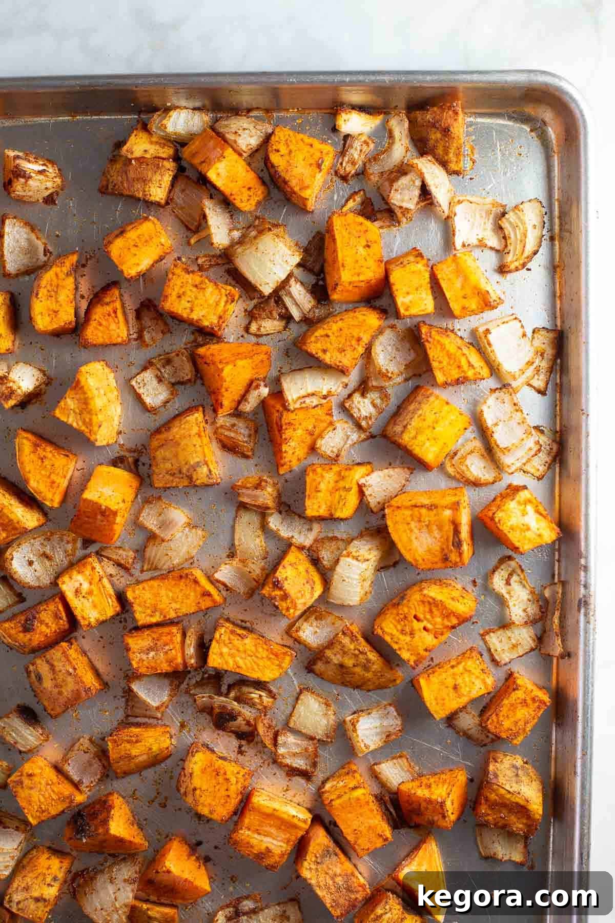 Perfectly Roasted Sweet Potatoes for Soup A sheet pan filled with beautifully roasted and caramelized sweet potatoes and sweet onions, glistening and tender, fresh out of the oven.