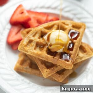 Golden Oat Waffles 8 gluten free waffle on white plate with syrup