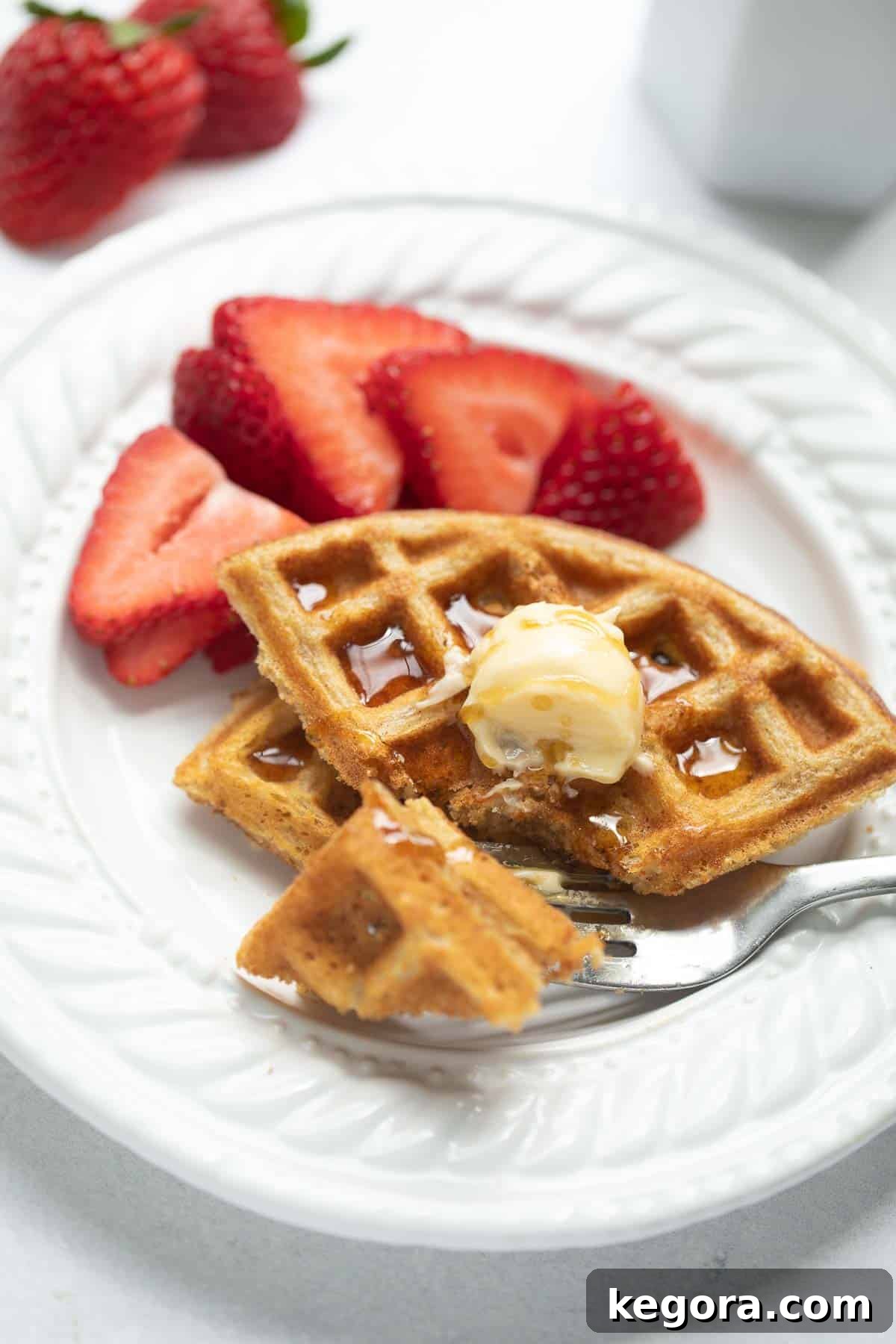 Golden Oat Waffles 7 Fork taking a bite of a perfectly cooked oat flour waffle, showing its light and crispy texture.