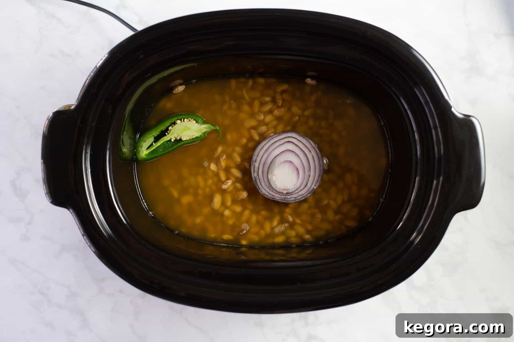 Cooking Beans in Slow-Cooker A slow cooker filled with Mexican beans, gently simmering and developing rich flavors.