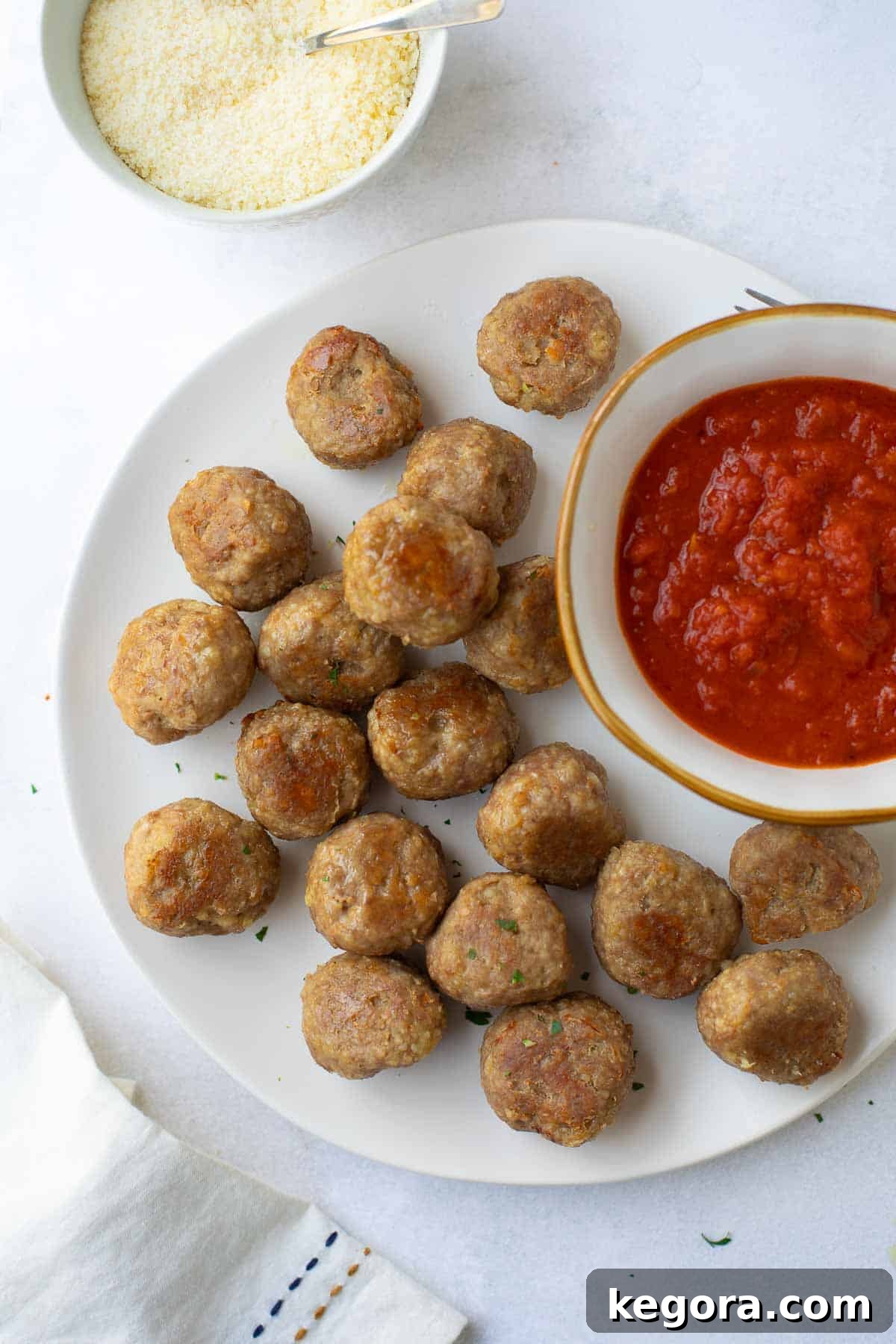 overhead shot of gluten-free turkey meatballs on white plate with marinara sauce