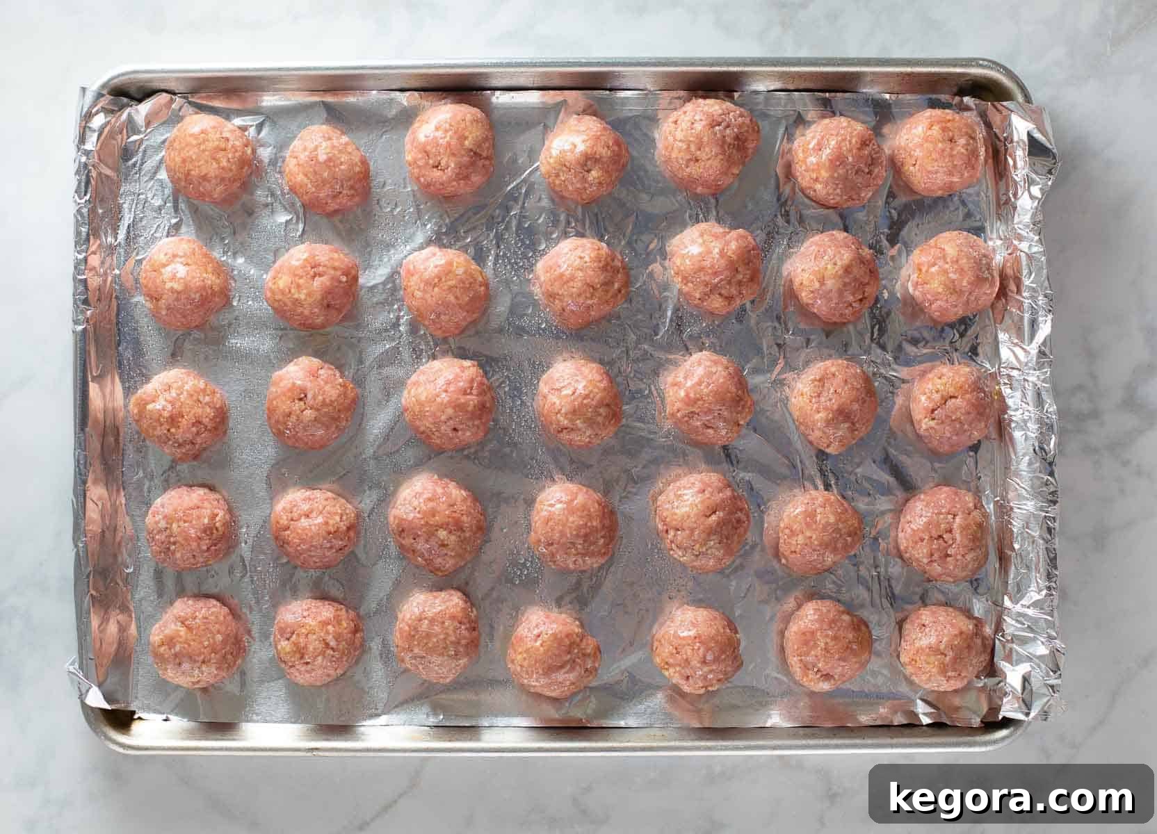 meatballs shaped and ready on a baking pan