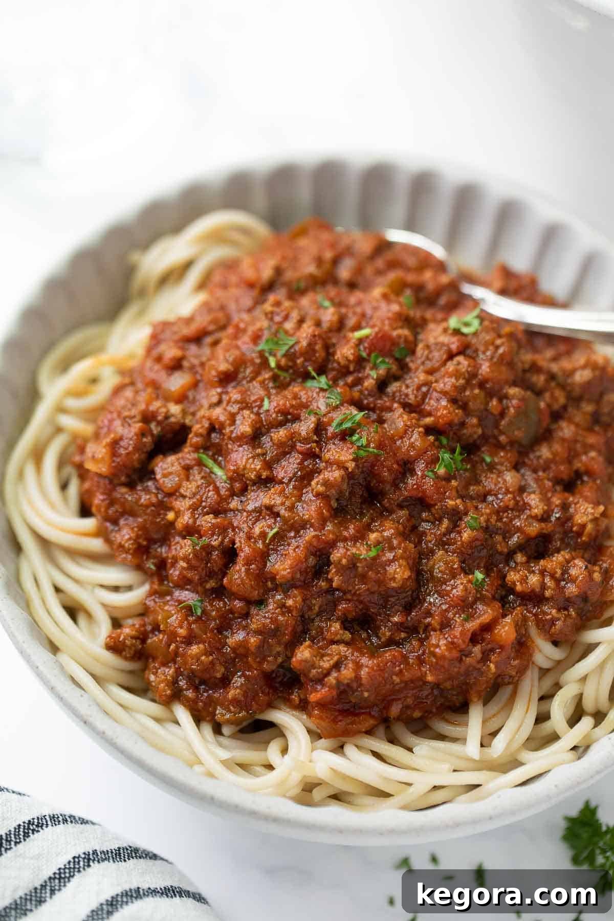 Perfect Gluten-Free Pasta Sauce 10 spaghetti sauce over cooked noodles in white plate.