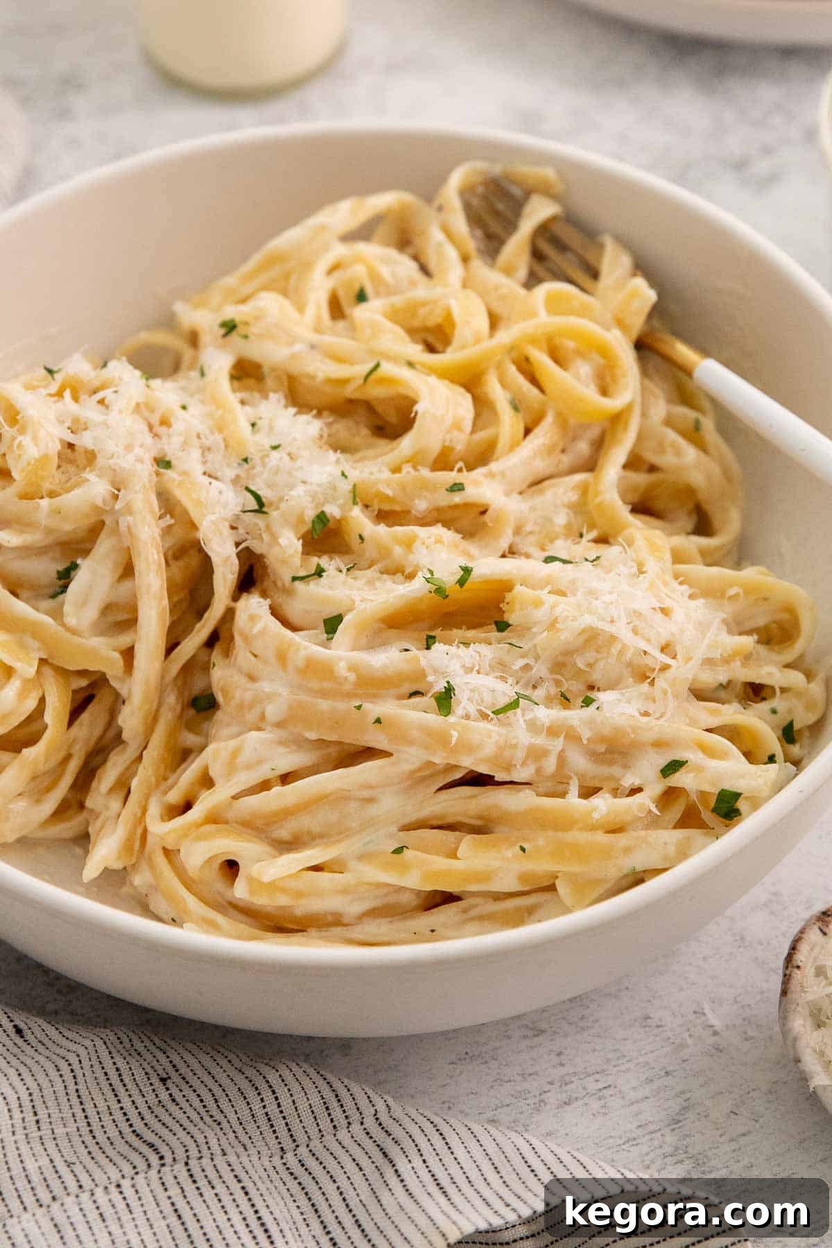 Fettuccine Alfredo in a bowl with a fork.