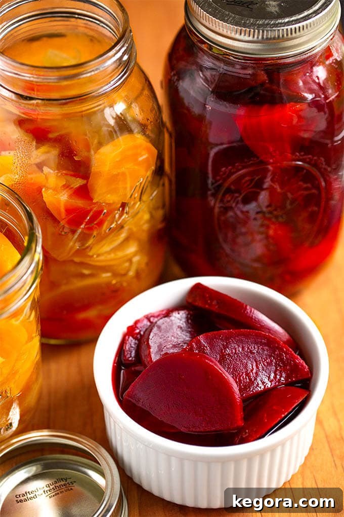 Pickled Beets in a small white bowl with canning jars in the background on wooden board