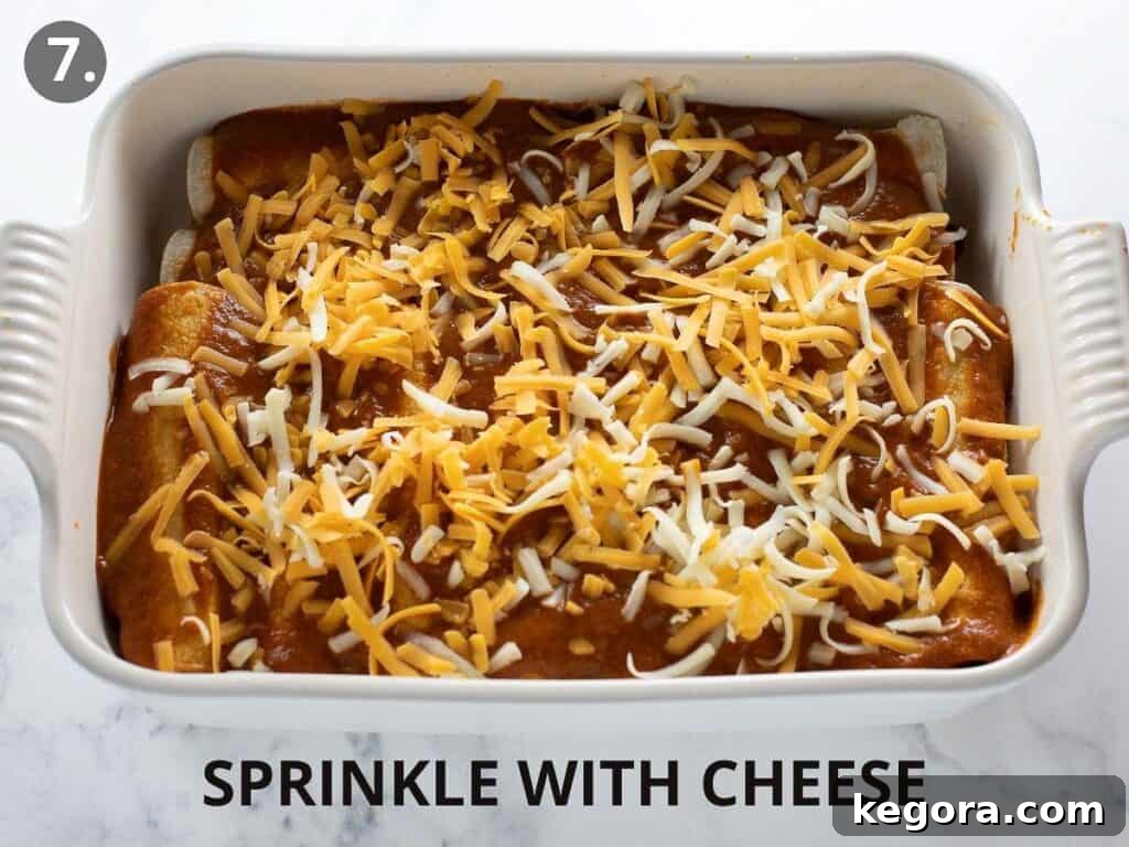 Savory Gluten Free Enchiladas 11 Gluten-free enchiladas in a white pan, generously covered with a layer of shredded cheese, before baking.