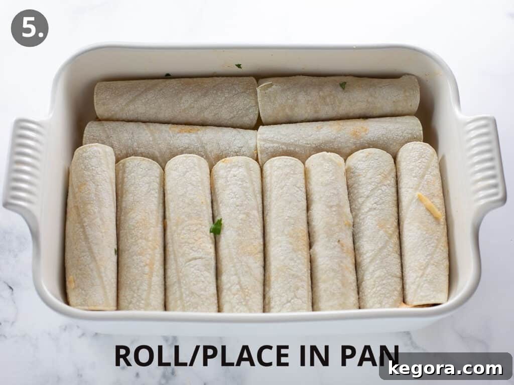 Savory Gluten Free Enchiladas 9 Rolled enchiladas neatly arranged in a white 9x13 baking pan, ready for sauce and cheese.