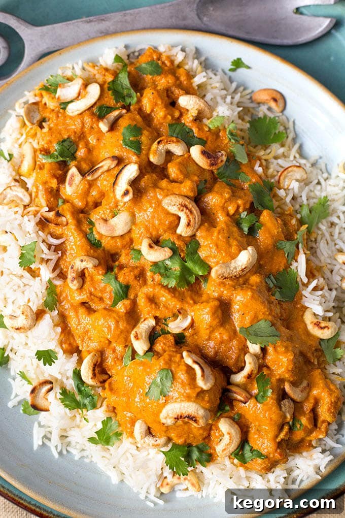Creamy Instant Pot Butter Chicken 8 A beautifully plated Instant Pot Butter Chicken, generously topping a bed of fluffy rice and garnished with toasted cashews and fresh cilantro for an elegant finish.