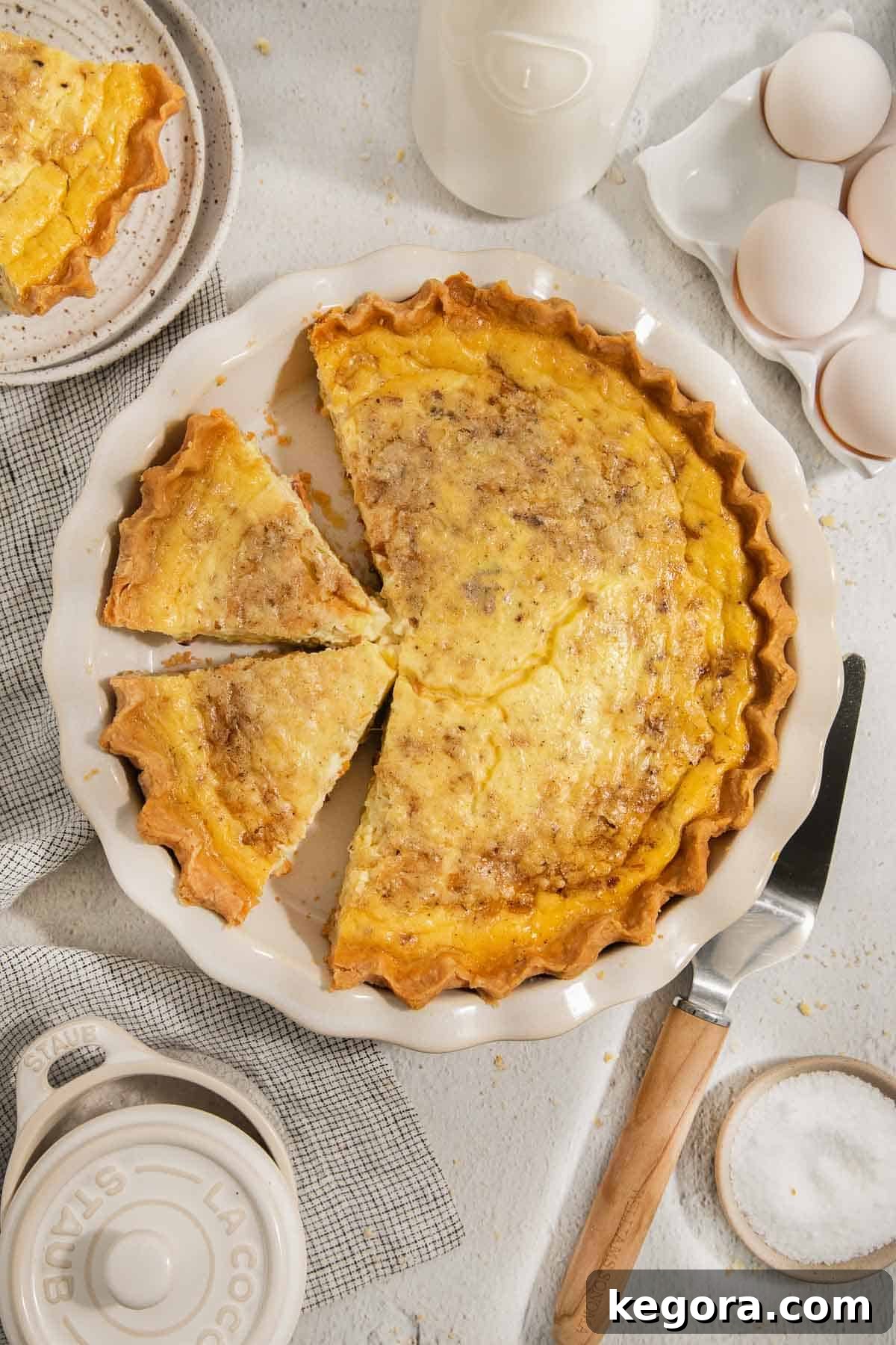 A beautifully baked gluten-free quiche Lorraine in a pie pan, ready to be sliced and served.