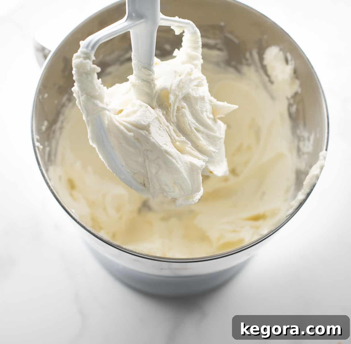 The Ultimate Gluten Free Vanilla Cake 8 A bowl of smooth, fluffy vanilla buttercream frosting, perfectly whipped and ready to adorn a cake.