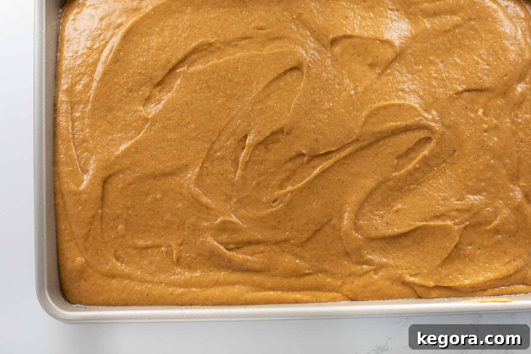 Guilt-Free Autumn Pumpkin Bars 7 Smooth pumpkin bar batter spread evenly into a baking pan, ready for the oven.