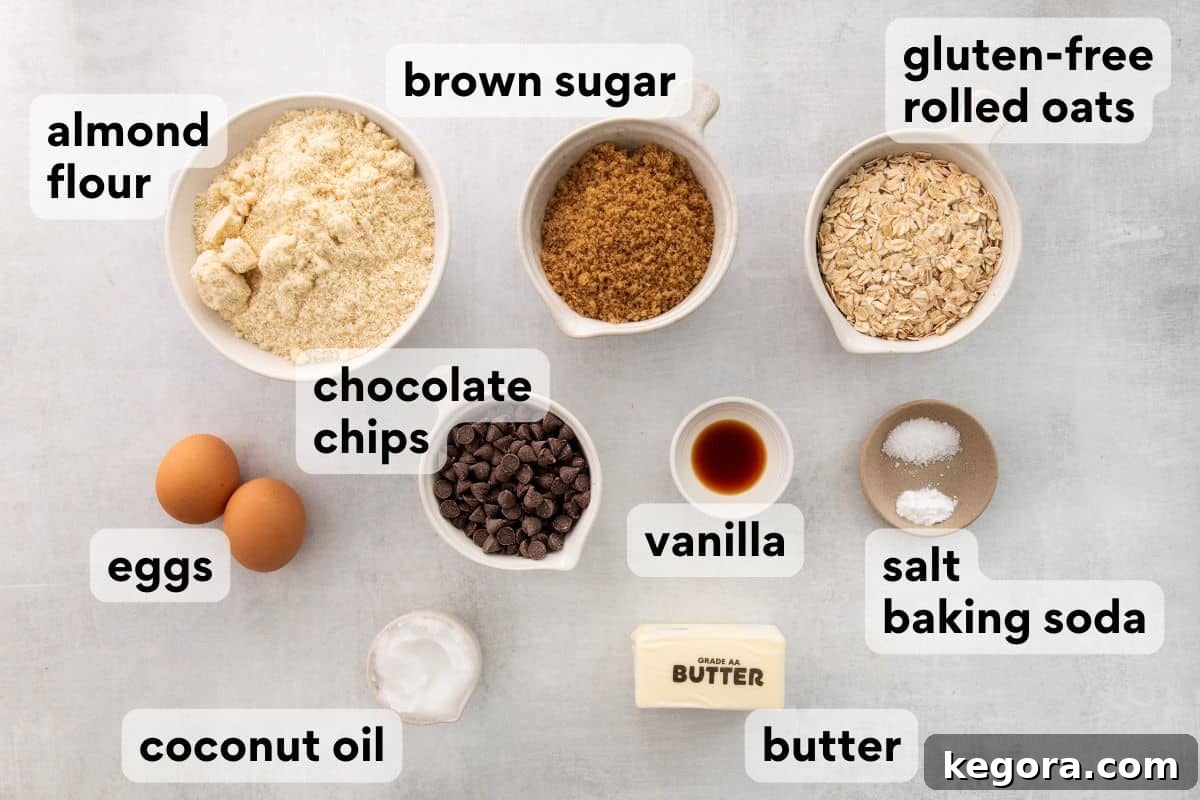 Carefully measured and labeled ingredients for almond flour oatmeal cookies, including blanched almond flour, gluten-free rolled oats, brown sugar, butter, and eggs, laid out on a clean counter.