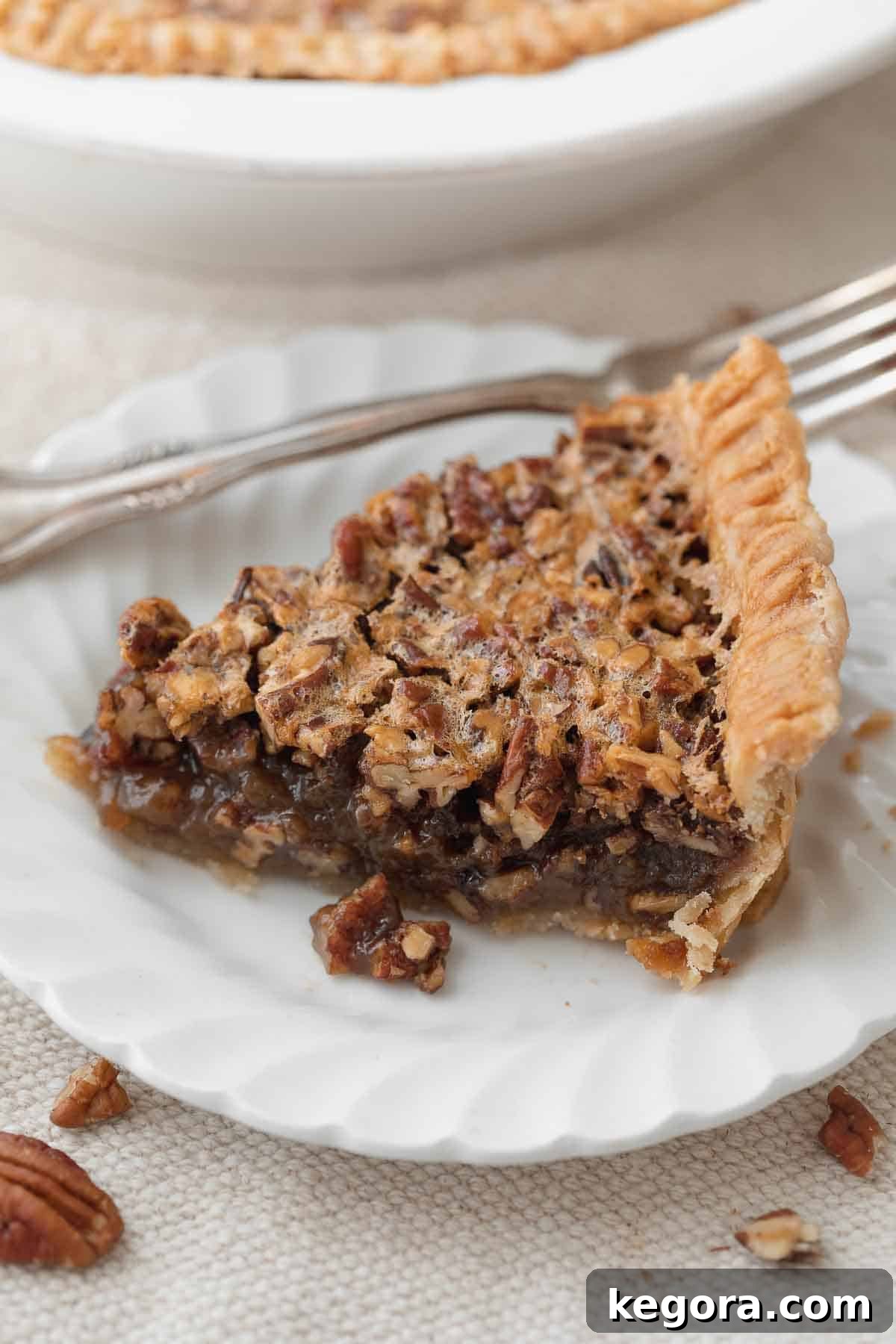 Decadent Gluten-Free Pecan Pie 2 slice of gluten free pecan pie on white plate with fork