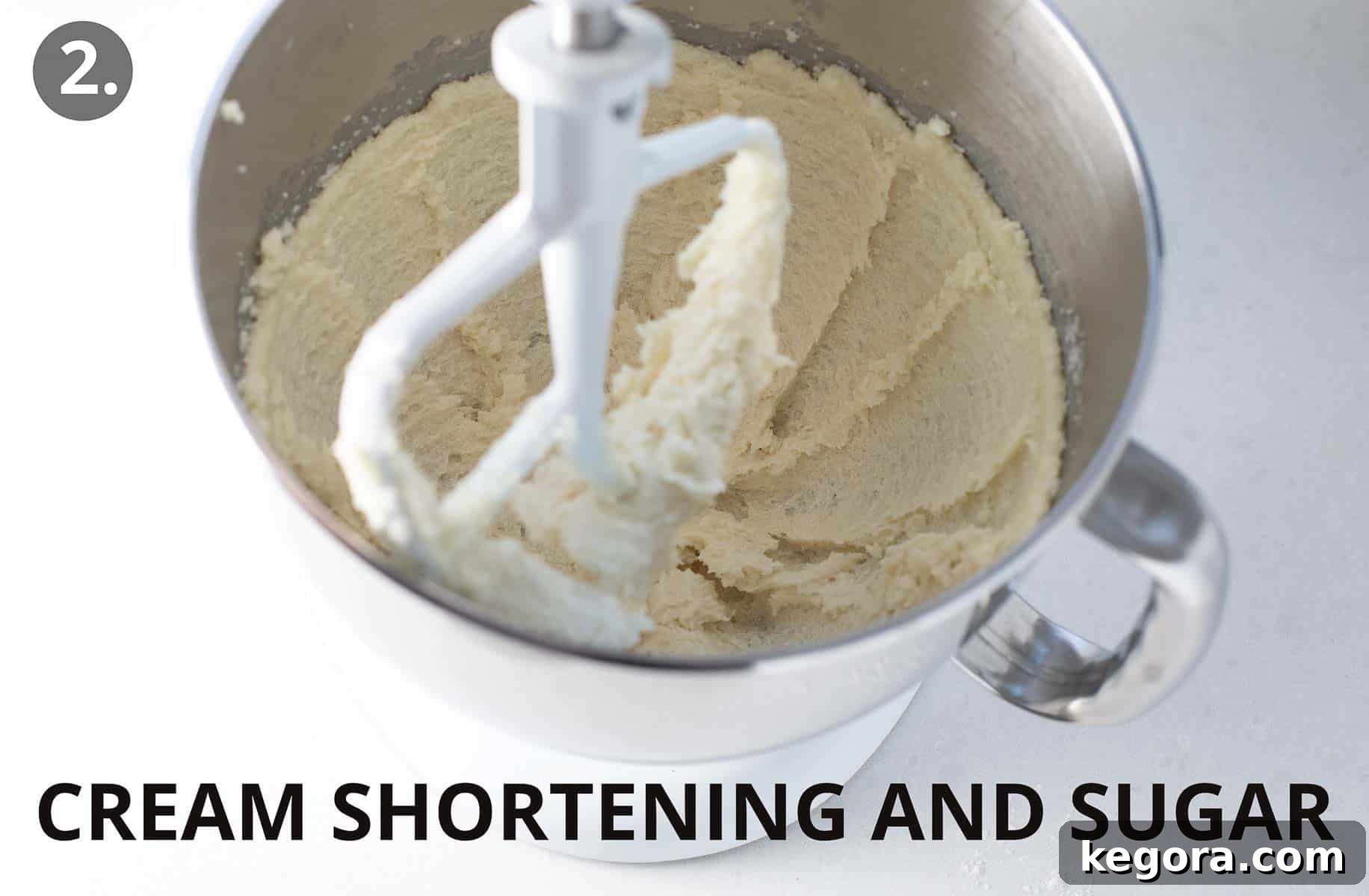 Spiced Gluten Free Gingerbread Delights 6 Shortening and granulated sugar being creamed together in the bowl of a stand mixer with a paddle attachment, creating a light and fluffy mixture.