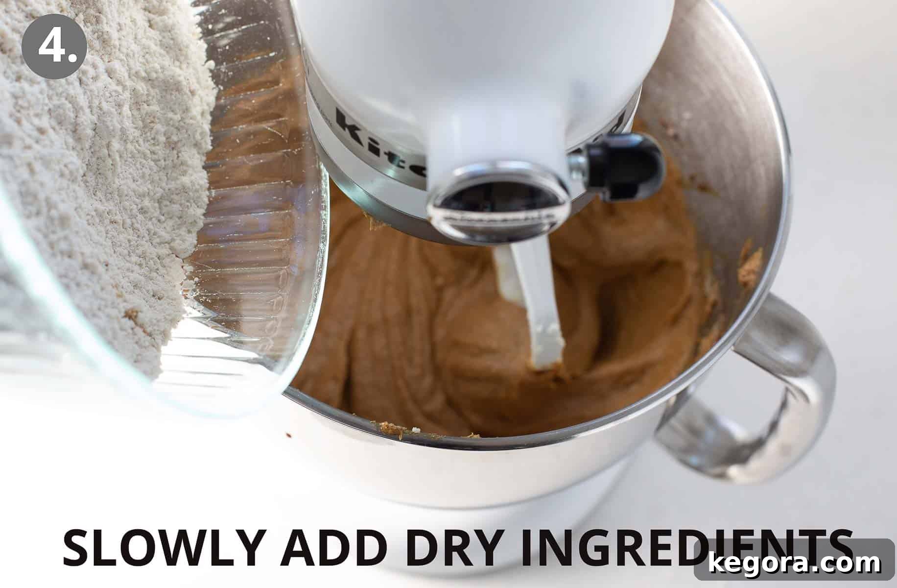 Spiced Gluten Free Gingerbread Delights 8 Dry ingredients being slowly added to the wet mixture in a stand mixer, blending to form a cohesive gingerbread cookie dough.
