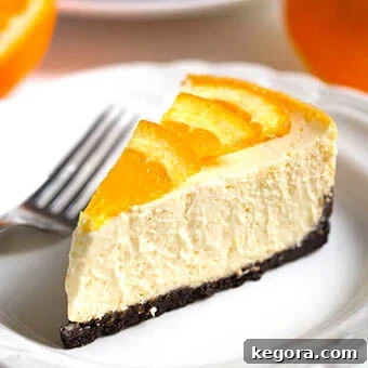 Slice of Dreamy Orange-Cheesecake on white plate with fork