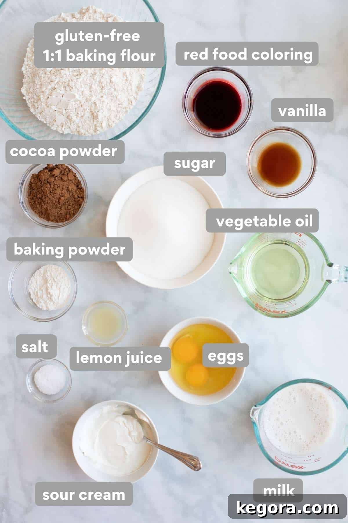 Overhead shot of all the ingredients needed to make gluten-free red velvet cupcakes laid out on a white surface.