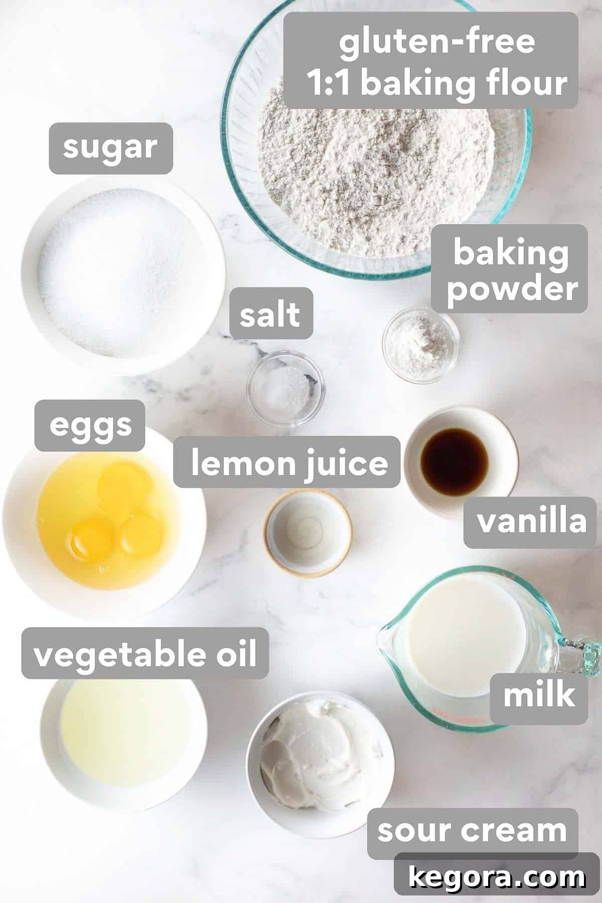 Ultimate Gluten-Free Birthday Cake 3 Overhead shot of all the essential ingredients laid out for making the vanilla cake, including flour, sugar, eggs, and sour cream.