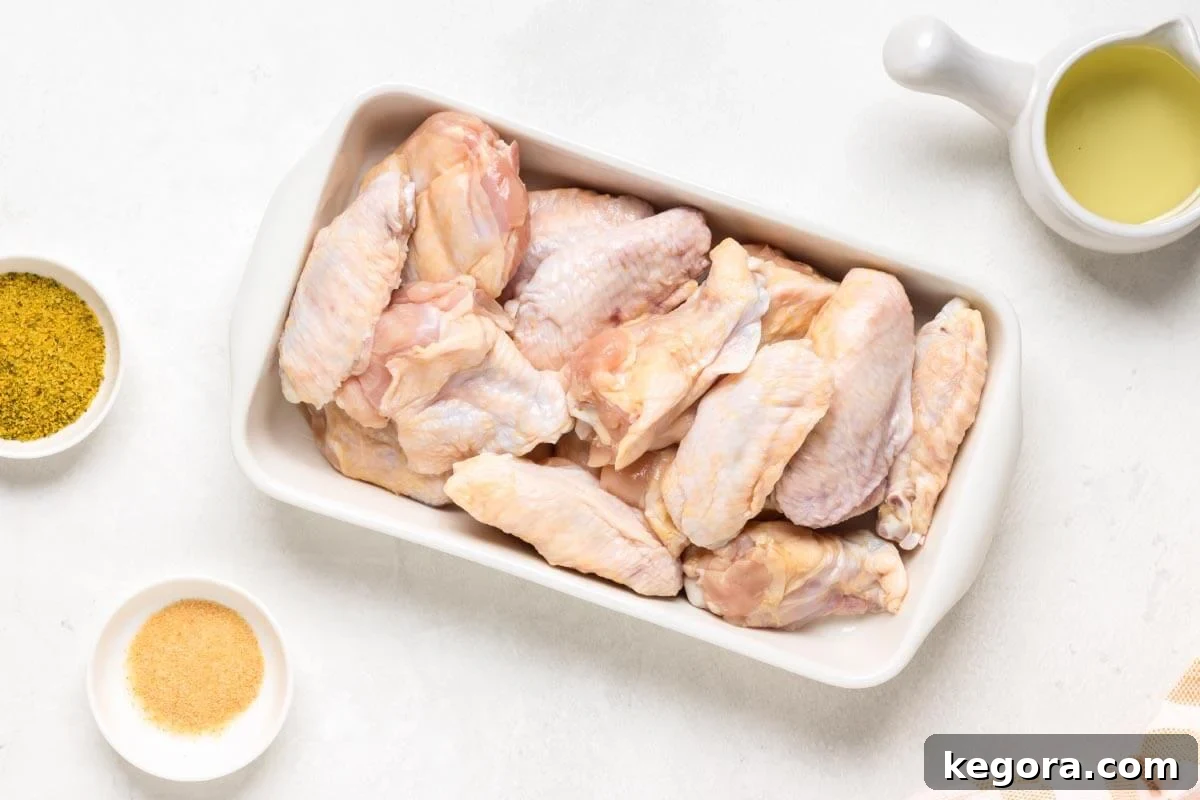 Raw chicken wings seasoned and ready for the air fryer, laid out in a tray.