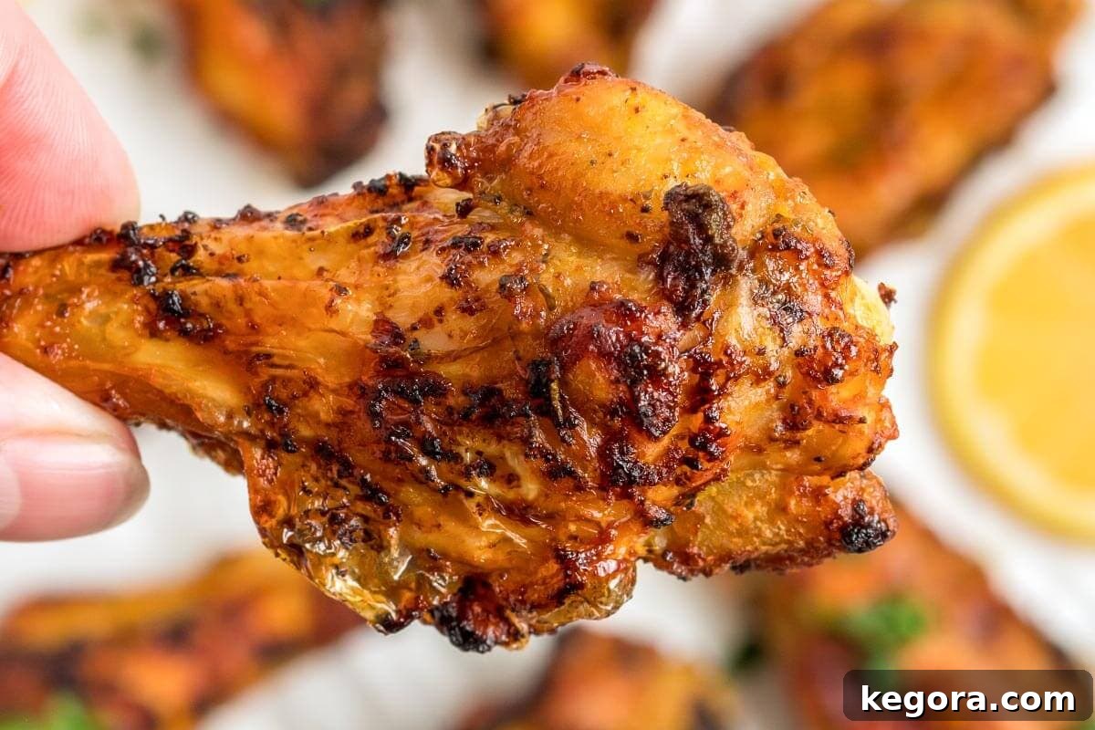 A single, perfectly air-fried chicken wing drumette, golden and crispy.