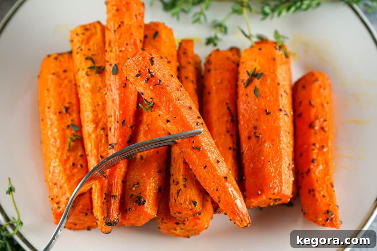 Crispy Air Fryer Carrots 3 Carrots on plate and fork.