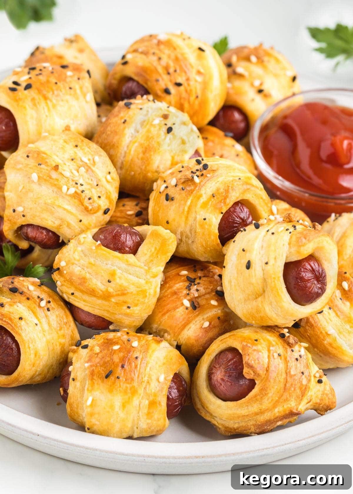 Golden brown Air Fryer Pigs in a Blanket arranged beautifully on a plate, ready to be served.