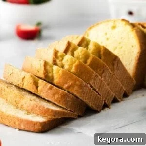 Several thick slices of golden-brown gluten-free pound cake, beautifully arranged on a rustic wooden table, showcasing its dense yet tender texture, perfect for any occasion.