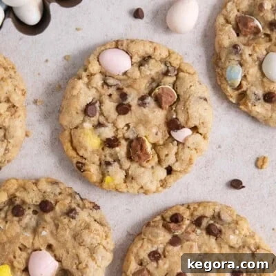A delectable pile of festive gluten-free Cadbury egg cookies, studded with mini chocolate chips and crushed Cadbury mini eggs, arranged on a countertop, promising a delightful Easter treat.
