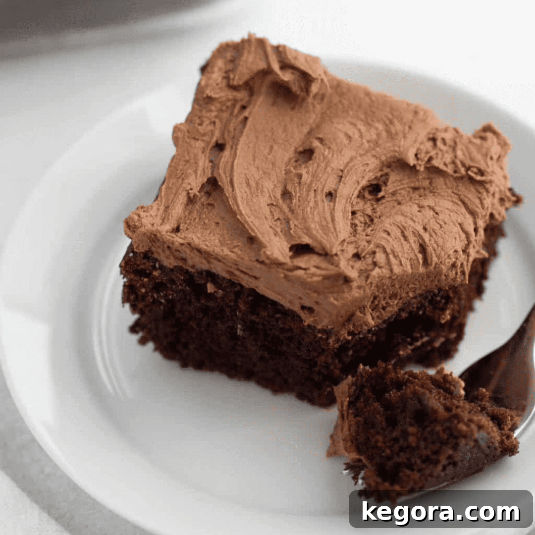 A generous slice of rich gluten-free chocolate cake topped with a swirl of chocolate frosting.