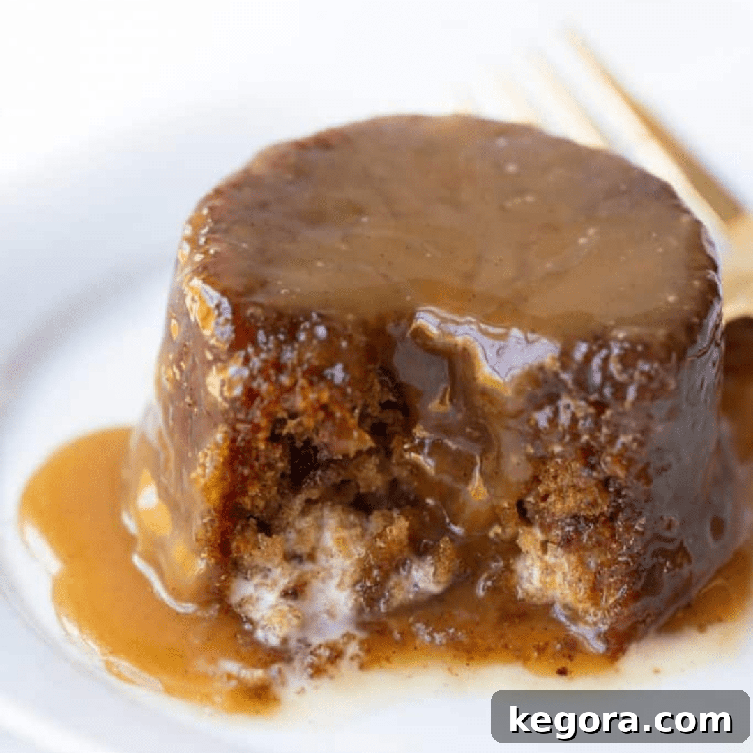A decadent gluten-free sticky toffee pudding cake served on a plate, drenched in its signature toffee sauce.