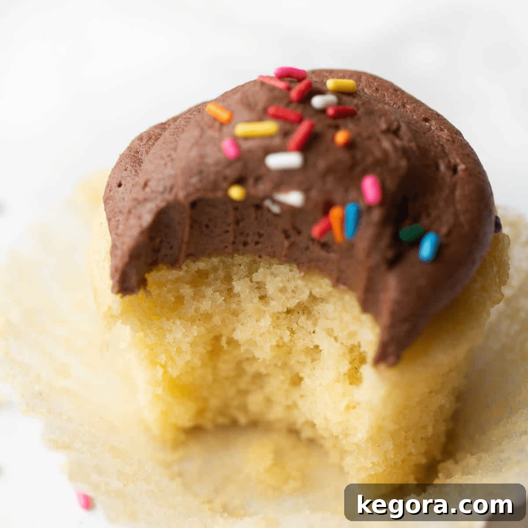 A perfect gluten-free yellow cupcake topped with a swirl of light frosting, ready to be enjoyed.