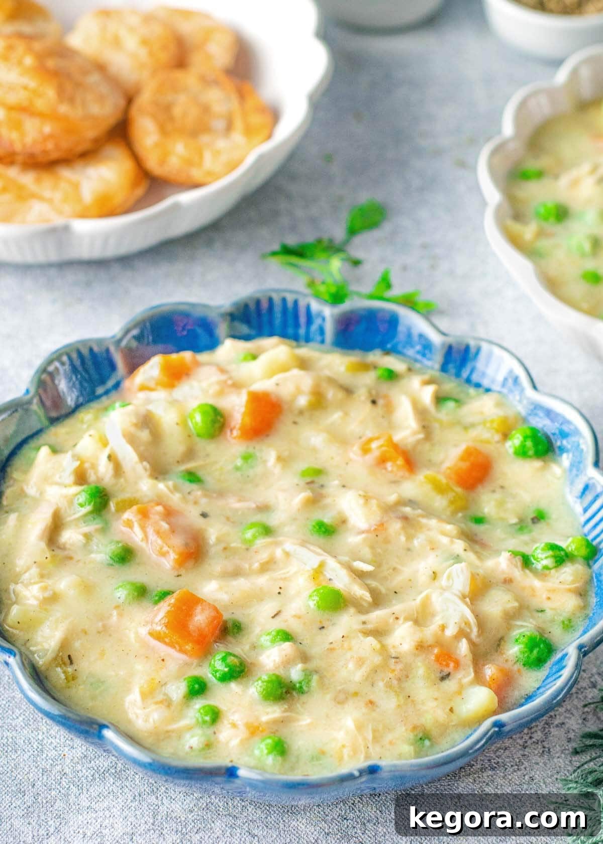 Instant Pot Chicken Pot Pie Soup in a blue bowl, presented beautifully on a wooden table.
