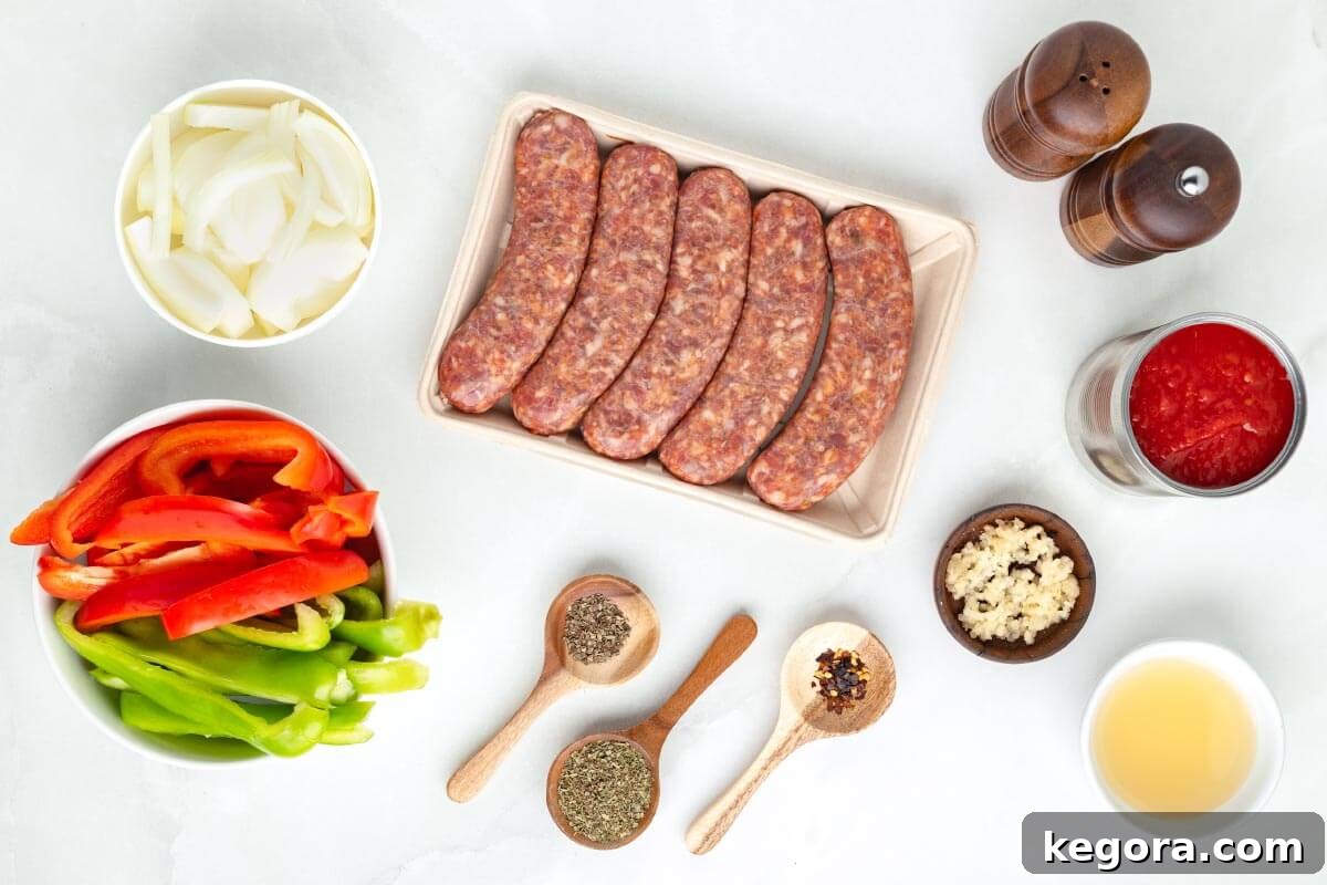 Set It and Forget It Sausage and Peppers 4 Fresh ingredients laid out for Slow Cooker Sausage and Peppers: Italian sausages, bell peppers, onion, garlic, can of crushed tomatoes, and spices.
