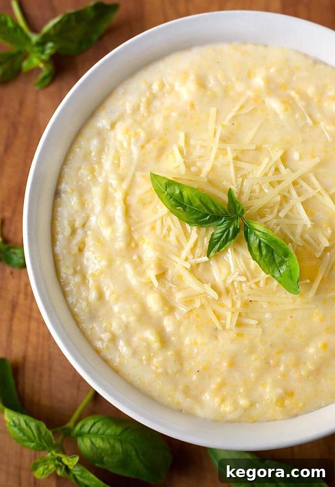 No-Stir Instant Pot Polenta 2 Polenta in a white bowl on a wooden board garnished with basil